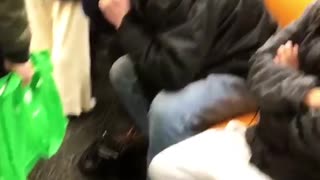 Man plays loud electric guitar with amp on ubway train