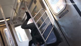 Guy in black jacket dancing head stand blue subway seat