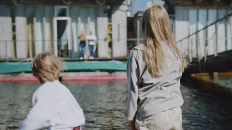 Two Kids Throwing Rocks in the River