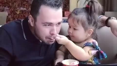 Cute baby eating food with father