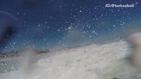 Guys red canoe get knocked over by wave beach