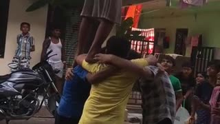Kids banding together to lift friend in pink shirt to take down and break pinata